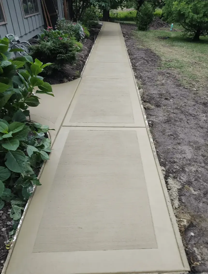 Long stained concrete sidewalk with tooled borders running beside a home — Cornerstone Concrete of WNY